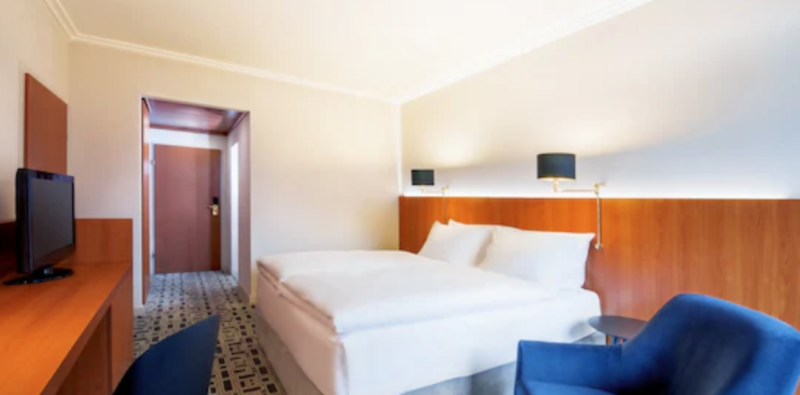 Chambre double de l'hôtel NH Prague City avec tête de lit en bois