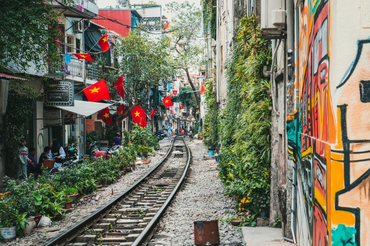 Rue du train à Hanoï, avec ses commerces au bord des rails et ses drapeaux vietnamiens