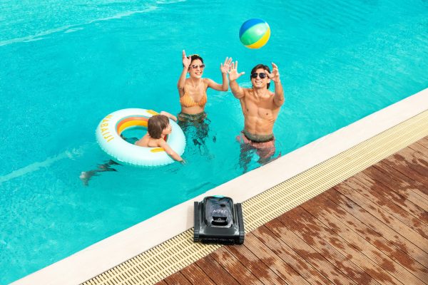 Famille heureuse qui joue au ballon dans une piscine lors de vacances pas chers
