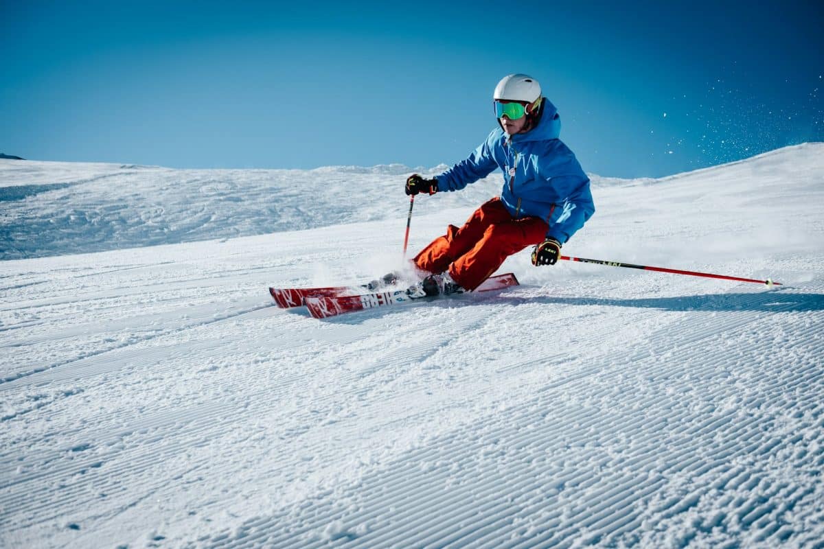 Jeune skieur qui dévale un pente pendant un séjour ski